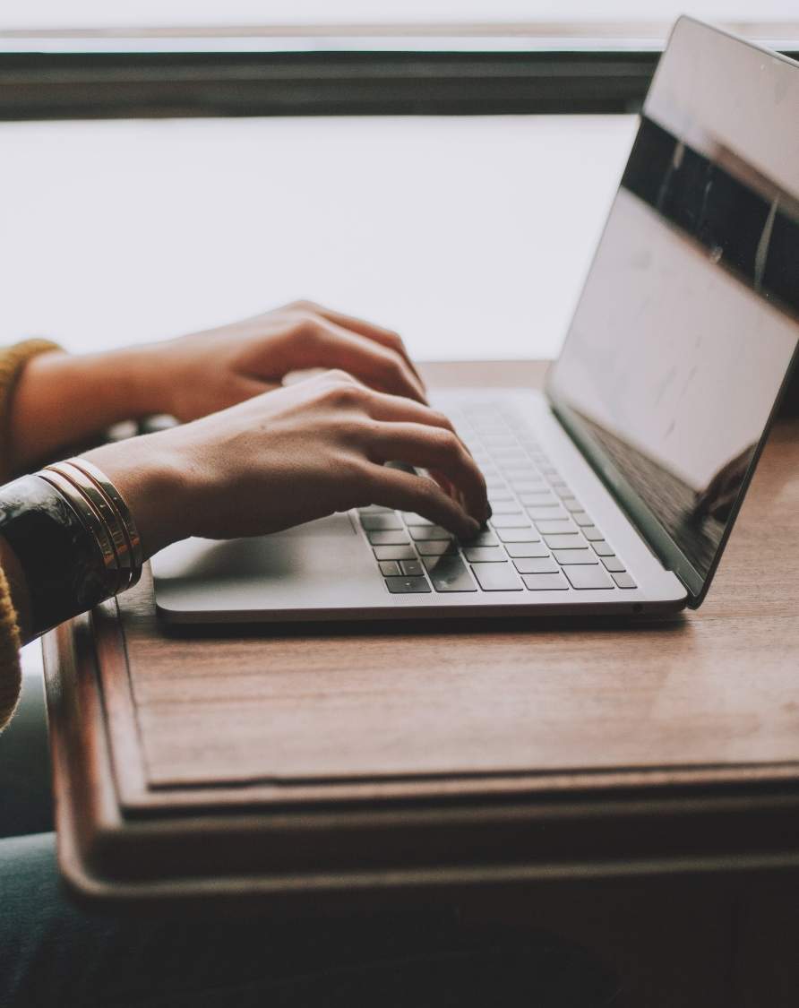 Image of hands typing on a laptop representing the convenience of IT automation using the Intoto platform.